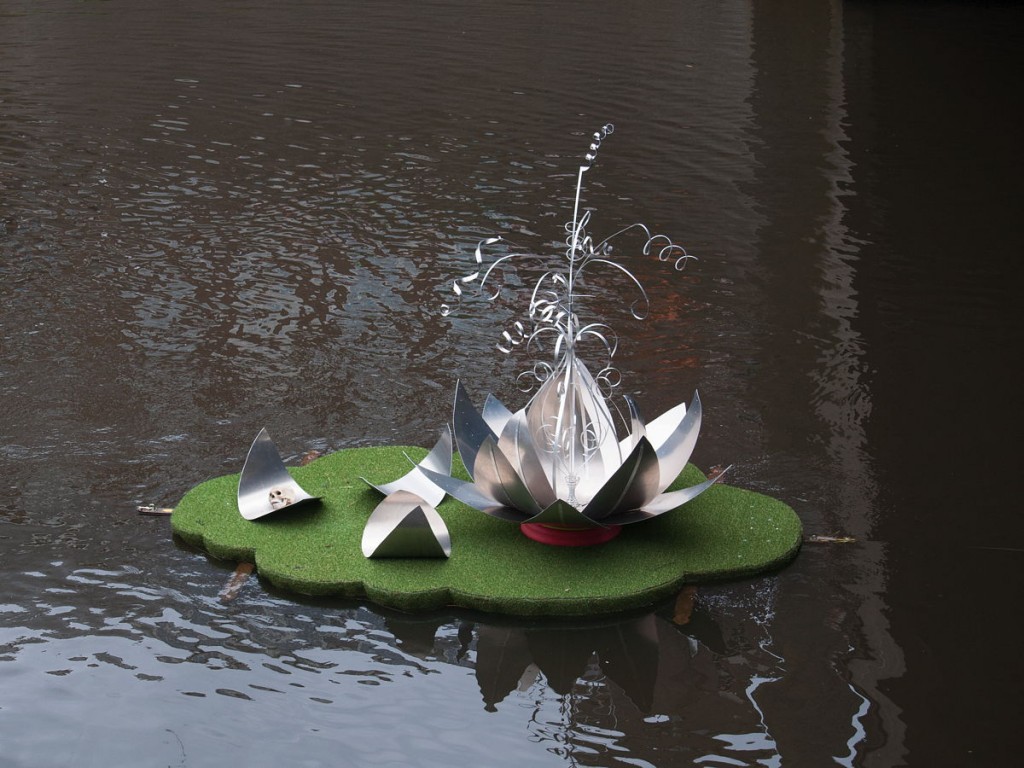 Drijvend graseiland met metalen lotusbloem (aluminium) met doodshoofd op de boschparade